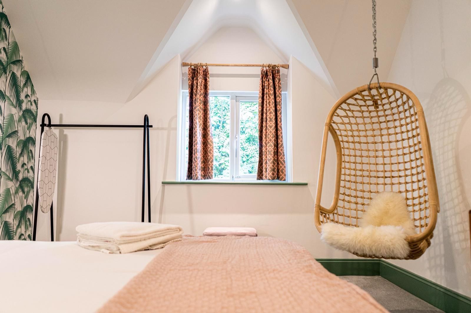 Jacobean Hotel bedroom with rattan bed and hanging chair